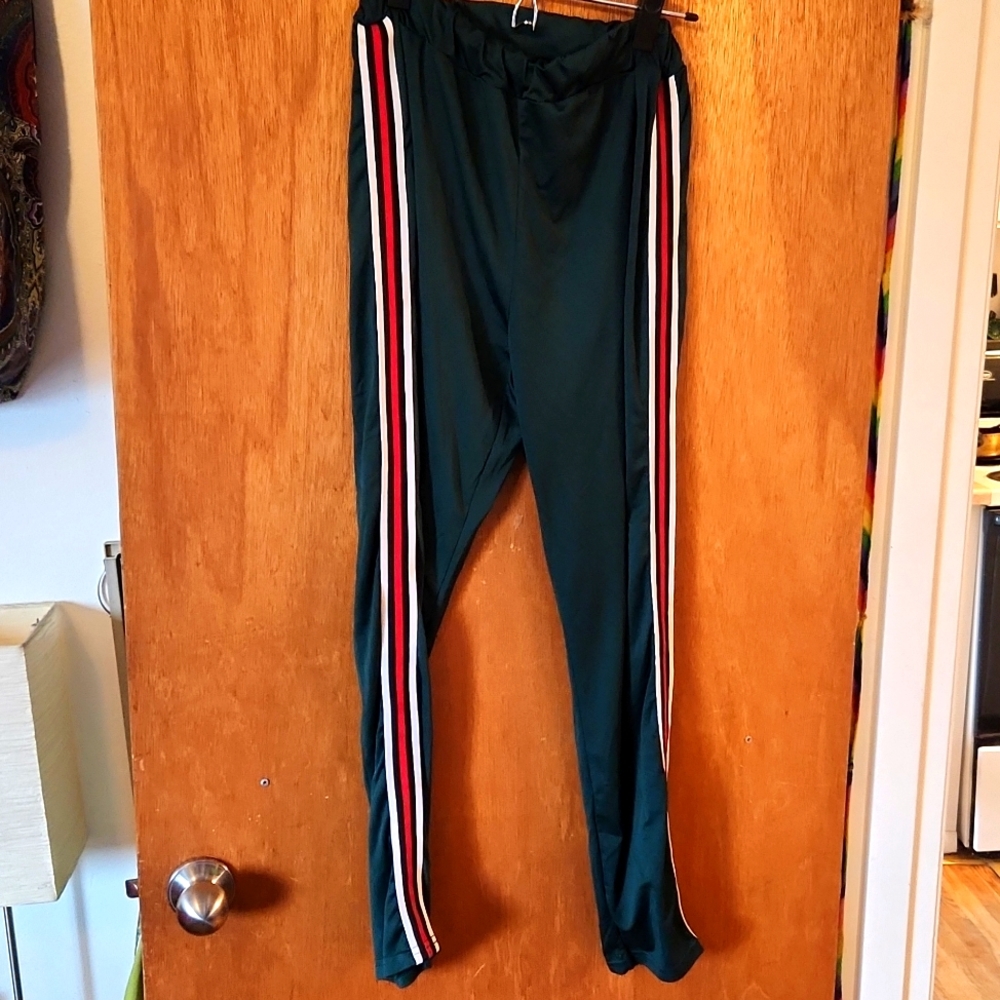 Forest green track pants with red, black and white stripes